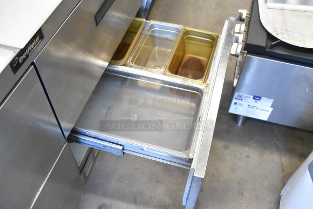 Delfield stainless steel prep table, 4 drawers, mega top, 115V, with over shelf. Includes pans. Used condition.