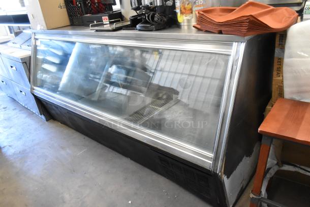 Leader Metal commercial deli display case, floor style, glass front, 115 volts, 1 phase, used condition with shelving visible.
