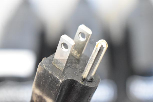 Close-up of a black power plug from a Narvon NSSM3 granita machine, showing two metal prongs and embossed numbering.