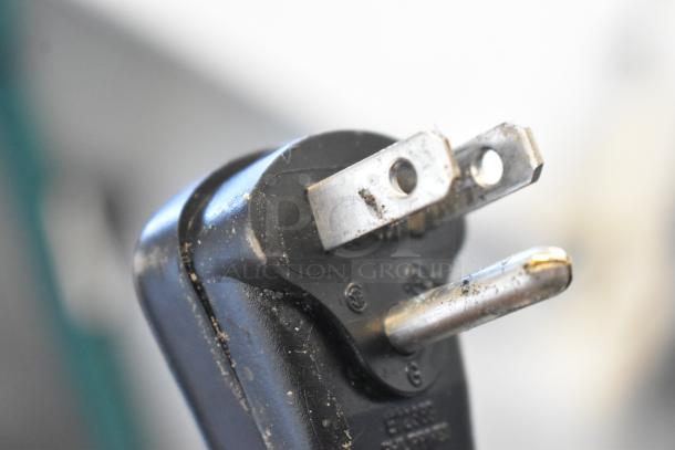Close-up of a power plug for Scotsman UC2024MA-1A ice machine, showing minor wear and dust.