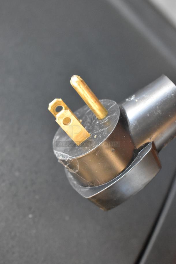 Close-up of power plug for Scotsman UC2024MA-1A ice machine, showing three-pronged design for 115 volts, 1 phase use.