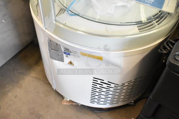 Brand new Avantco 193BCR15HCW white circular glass refrigerated display case, 115V, with labels indicating caution and specs.
