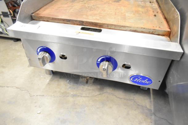 Globe Stainless Steel Gas Flat Top Griddle, commercial countertop model, two blue knobs, visible rust and wear on griddle.