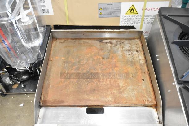 Globe stainless steel commercial countertop gas griddle, flat top, visible wear, used condition, caution labels present.