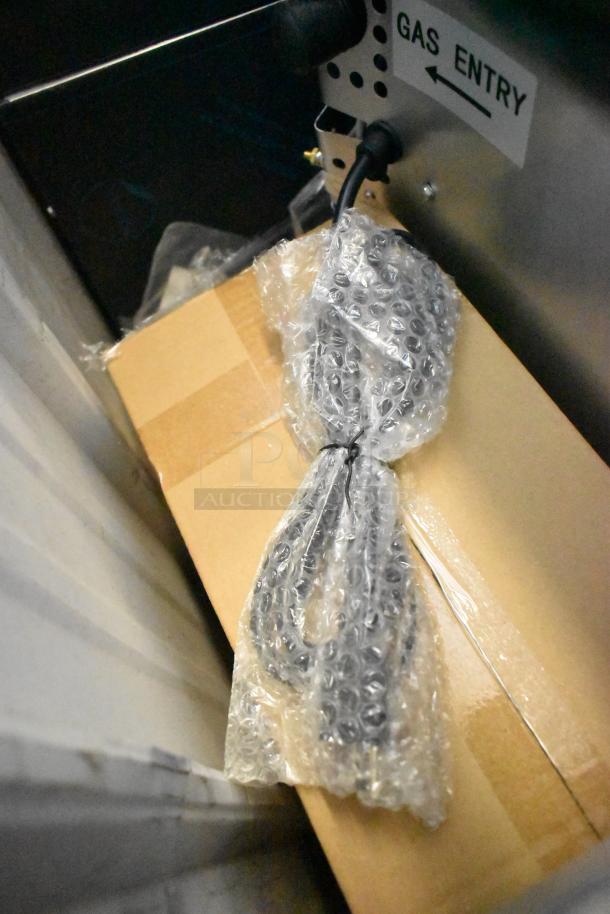 Packaging of the Cooking Performance Group FEC-100-C convection oven. Bubble-wrapped items and "GAS ENTRY" label visible.