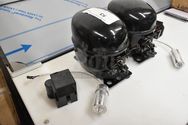 Two brand new Cubigel compressors, models NUT55NR and NUT70NR, 115-127V, 1 Phase, scratch and dent condition.