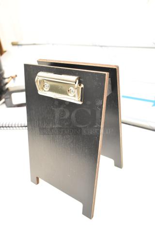 Standing clipboard, brand new with minor scratches and dents, black finish, metal clip, auctioned in a lot of 9.