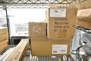 Three boxes on a metal shelf, including Carlisle steam pans. Labels show model numbers 607134 and 607132, six pieces each.