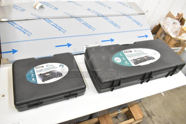 Two new Choice portable butane stoves in cases; 1-burner (15,000 BTU) and 2-burner (30,000 BTU), labeled and ready for use.
