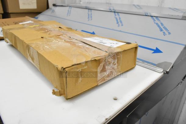 Cardboard box with taped edges containing new Choice 14" aluminum wide rim pizza pan and American Metalcraft NSC10 table stands.