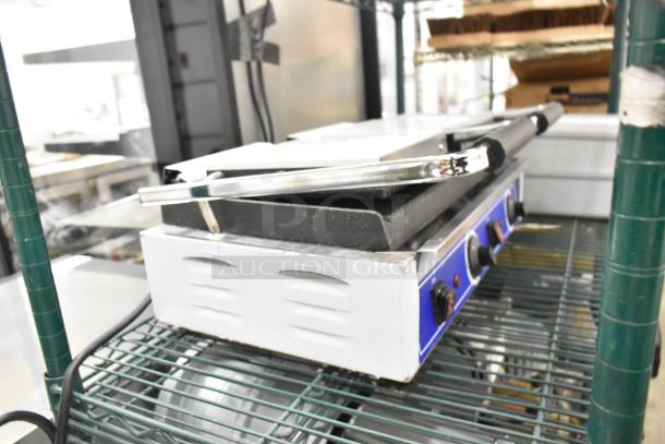 Brand new Globe stainless steel double panini press with minor scratches, dent visible; commercial countertop model.