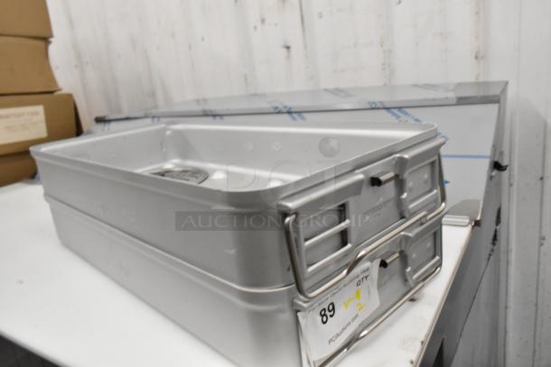 Two new Aesculap JN440 metal bins, with slight imperfections, stacked. Label indicates quantity and auction site.
