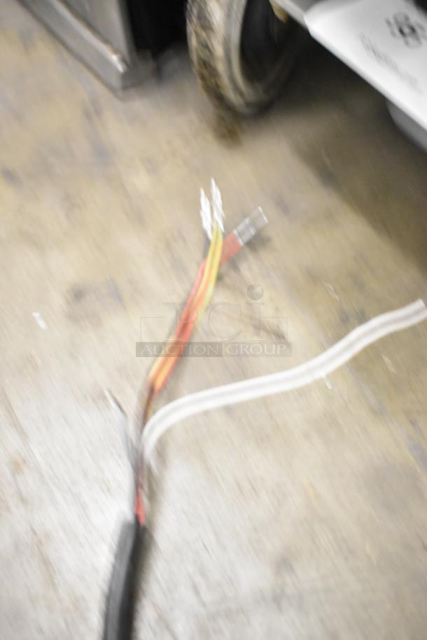 Blurry image of wires on the floor, possibly related to a Nidec Motor. Condition details unclear.