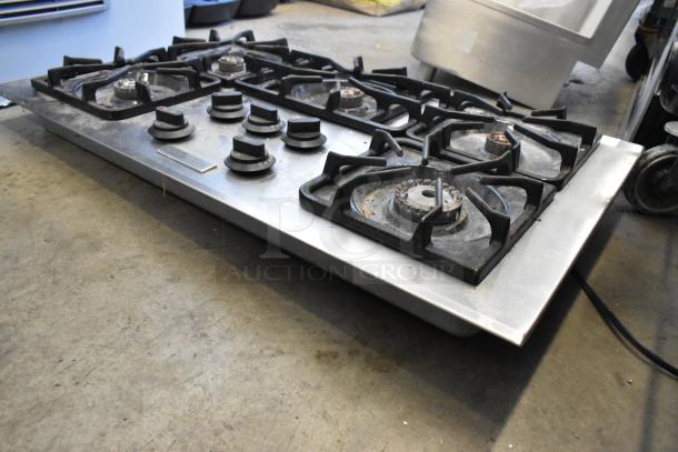 Frigidaire PLGC36S9CCB gas range with 5 burners, showing moderate wear. Metal surface with knob controls and burner grates.