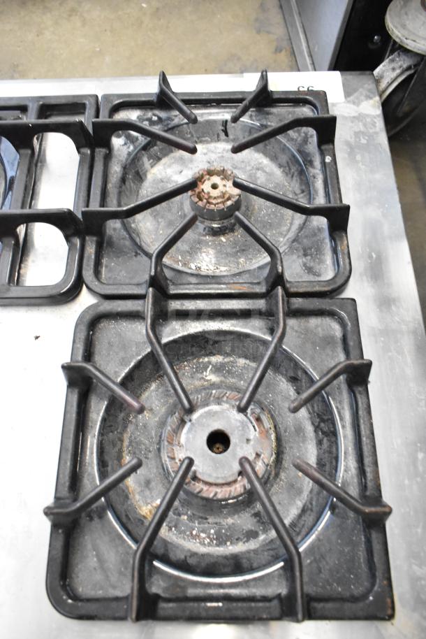 Frigidaire PLGC36S9CCB gas 5 burner range with visible rust and wear on burners, model tag partially visible.