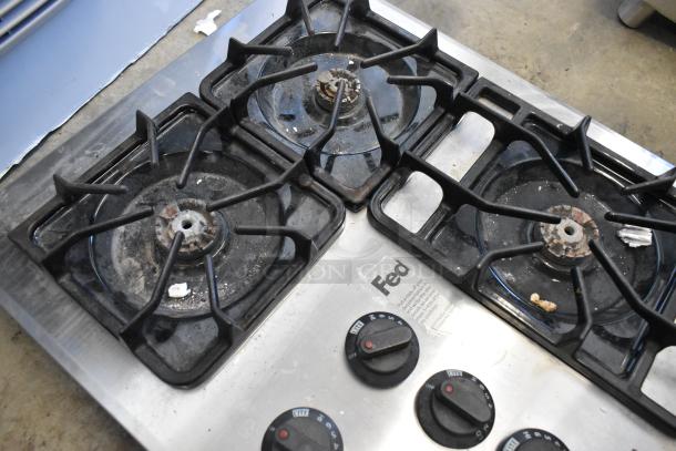 Frigidaire PLGC36S9CCB gas 5 burner range, black grates on stainless steel, visible wear, model label intact.