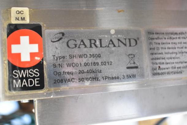 Garland SH/WO 3500 electric wok induction range, stainless steel, 208V, 1 phase, model info and Swiss made label visible.