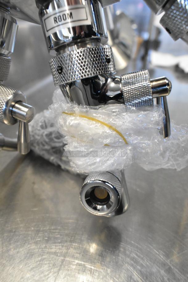 Stainless steel control valve with knurled grips, wrapped in protective bubble wrap, labeled "ROOM."