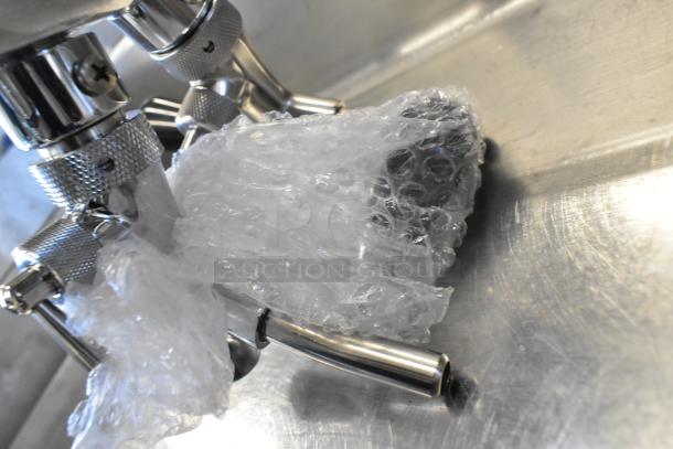 New Hatco RMB-7M Control Box, Avantco Axle Assembly wrapped in bubble wrap, resting on metal surface.