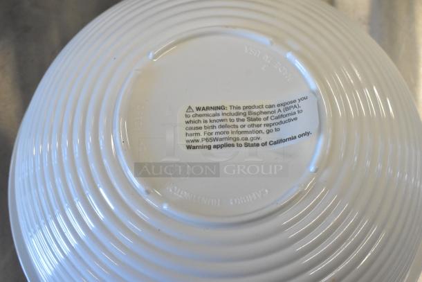 White poly bowl with warning label about BPA exposure. Bowl has grooved design and is part of an auction lot with Steelite spoons.