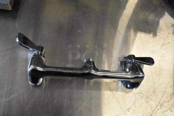 Chrome faucet with dual handles and threaded connections on stainless steel surface, part of a 4-item auction set.