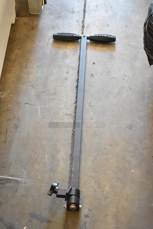 Metal long-handled tool with black plastic grips and adjustable knob, laying on concrete floor, marked "Kasei" on handles.