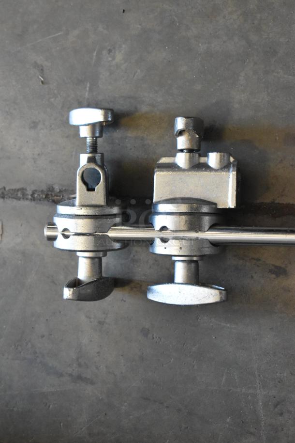 Set of four metallic faucet handles and parts, sturdy construction, shown on a gray surface. Ideal for plumbing repairs.