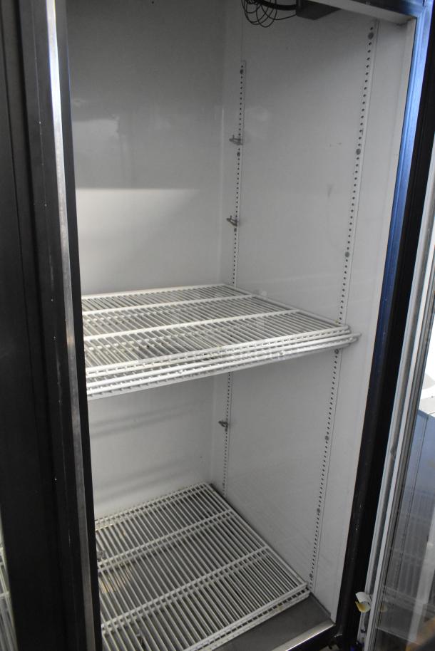 True GDM-72 three-door reach-in cooler, featuring poly-coated racks, 115V, 1 Phase, clean interior, metal construction.