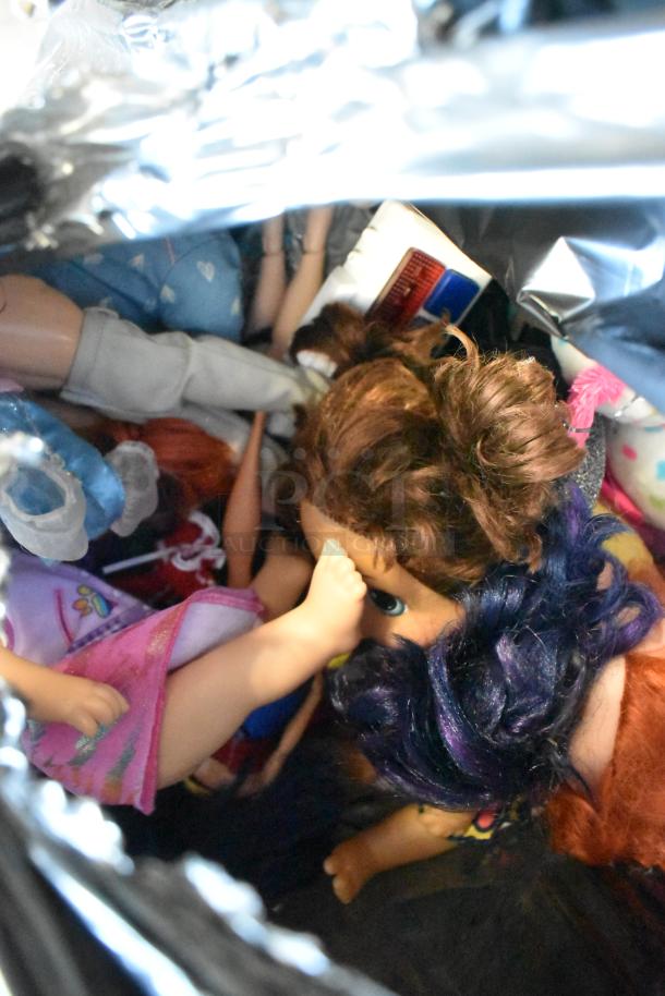 Lot of assorted dolls and items in various conditions, featuring diverse clothing and accessories, some hair visible.