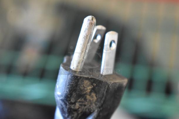 Close-up of a power plug, part of the 2024 Bunn SINGLE AXIOM 15 coffee brewer. Features standard prongs, 120 volts, 1 phase.