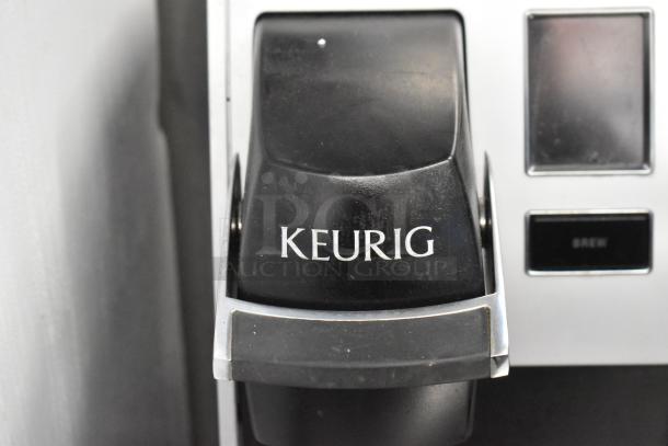Keurig K150 single cup coffee maker, countertop model, features brew button, slightly worn condition.