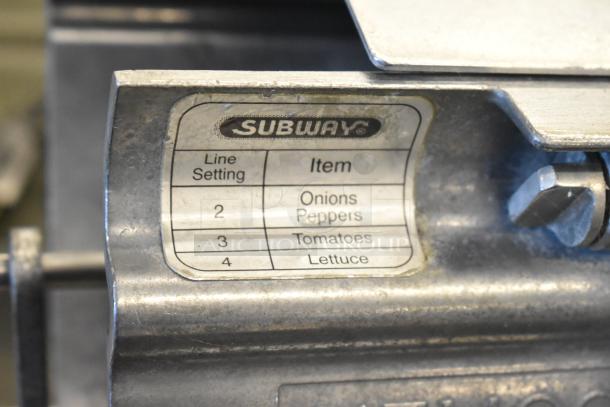 Nemco metal countertop vegetable slicer, mounted, with visible settings label for slicing onions, peppers, tomatoes, and lettuce.