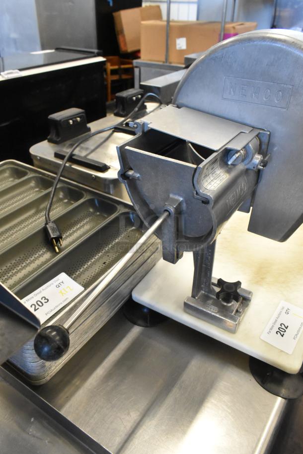 Nemco metal countertop vegetable slicer on mount, durable condition, visible brand marking "NEMCO," with power cord attached.
