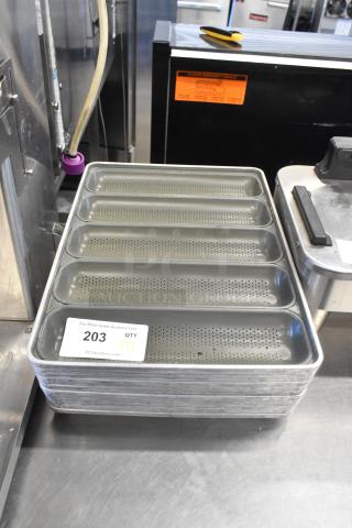Stack of 12 metal 5-loaf perforated baking pans in good condition. Labeled "203 QTY X12" by PCIAuctions.com.