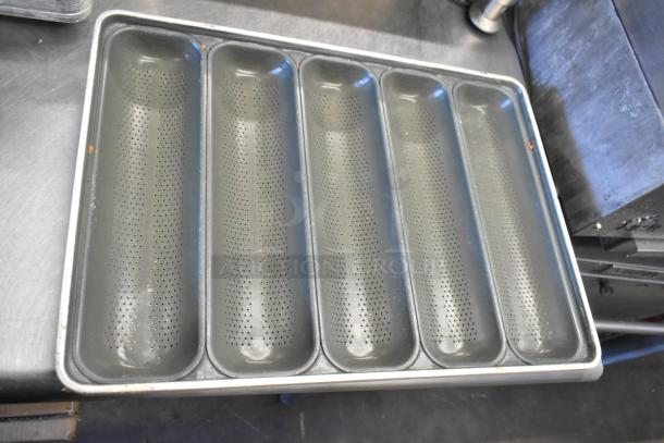 Set of 12 metal baking pans with perforations for 5 loafs each. Good condition, ready for bulk baking needs.