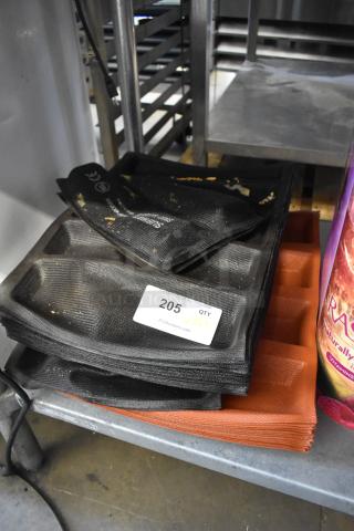 Stack of various baking pan liners, including 4-loaf and 5-loaf sizes, in good used condition. Contains 62 pieces.