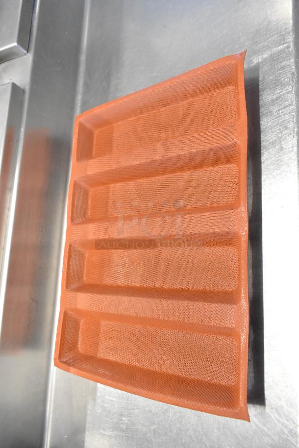Orange silicone baking pan liner with five loaf molds shown on a metal surface. Excellent condition.