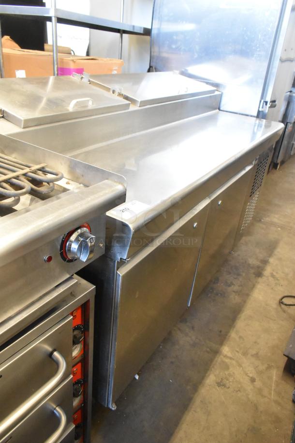 Stainless steel pizza prep table on commercial casters, 115 volts, 1 phase, features refrigeration and storage space, good condition.