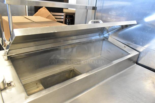 Stainless steel commercial pizza prep table with hinged lid and spacious interior, on commercial casters, 115V, 1 phase.