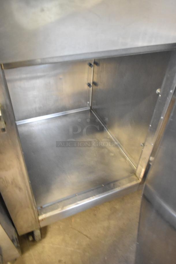 Traulsen RLT132WREHHS stainless steel fridge interior, 2 half-size doors, commercial casters, clean condition.