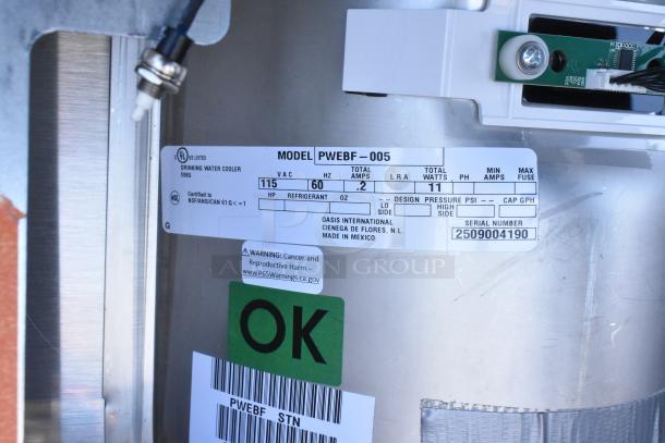 BRAND NEW Oasis PWEBF-005 stainless steel water fountain with label indicating 115V, 60Hz, NSF certified, serial 2509004190.