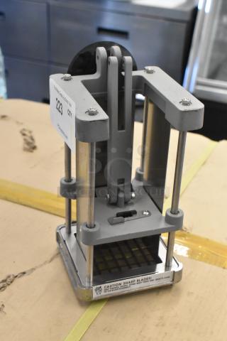 Metal countertop vegetable cutter with sturdy frame, sharp grid blades. Visible caution label. In good condition.