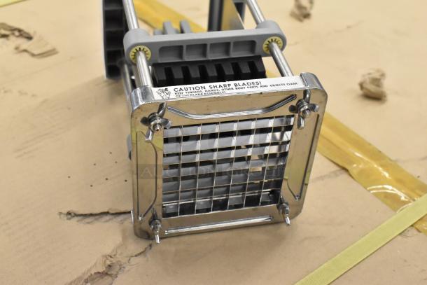 Metal countertop vegetable cutter with sharp blades, grid design, and caution label. Appears in good condition.