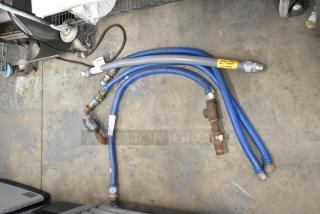 Four various gas hoses in used condition, featuring blue and gray tubing with metal connectors and visible labels.