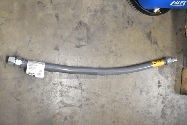 Gray gas hose with metal fittings and visible Dormont label on concrete floor, indicating brand and specifications.