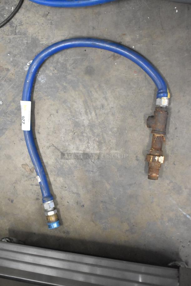 Blue gas hose with connectors, visible wear and rust on fittings, tag labeled "226," auction item condition.
