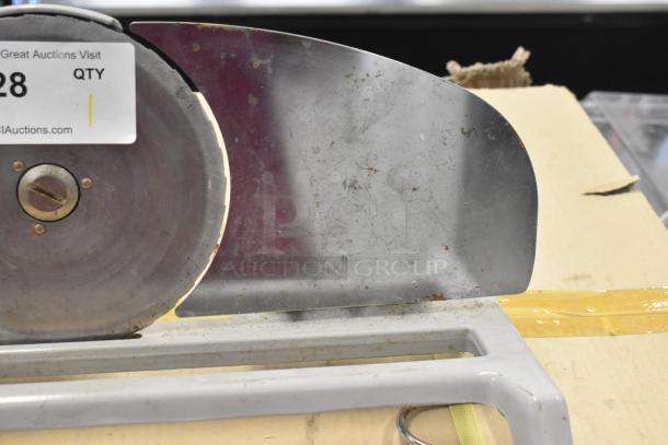 Metal countertop manual meat slicer with a circular blade. Visible wear and rust spots. Auction tag present.