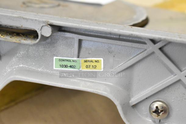 Metal countertop manual meat slicer, featuring a visible control number 1030-402 and serial number 0712 on the frame.