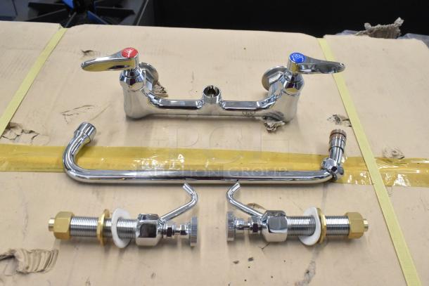 Chrome kitchen faucet set with dual handles marked with red and blue color indicators, placed on a cardboard box.