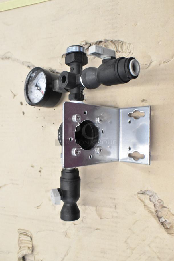 Industrial mounting bracket with attached pressure gauge and valve, metal and plastic components, used condition.